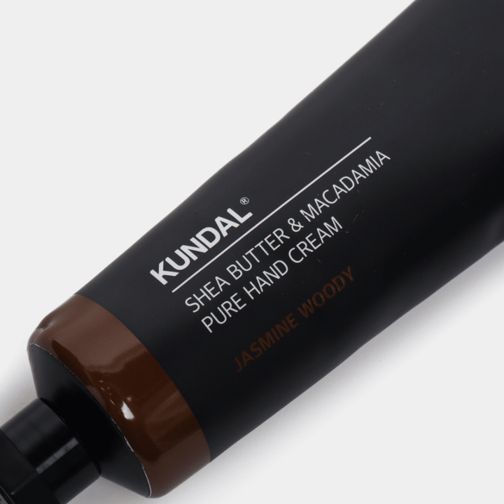 Nærbillede af KUNDAL Shea Butter & Macadamia Pure Hand Cream Jasmine Woody som viser den stilrene emballage og håndcremens premiumfølelse.