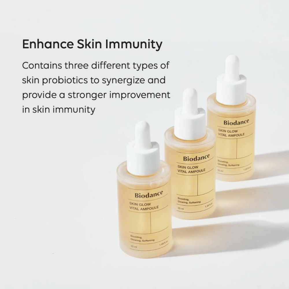 Tre flasker af Biodance Skin Glow Vital Ampoule vises med teksten 'Enhance Skin Immunity'. Produktet indeholder tre forskellige typer hudprobiotika, der styrker hudens immunitet og forbedrer dens beskyttelse.