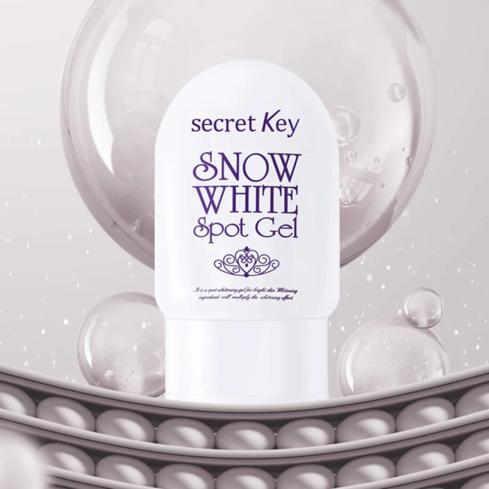 Secret Key Snow White Spot Gel i hvid emballage mod baggrund med bobler og perlelignende detaljer.