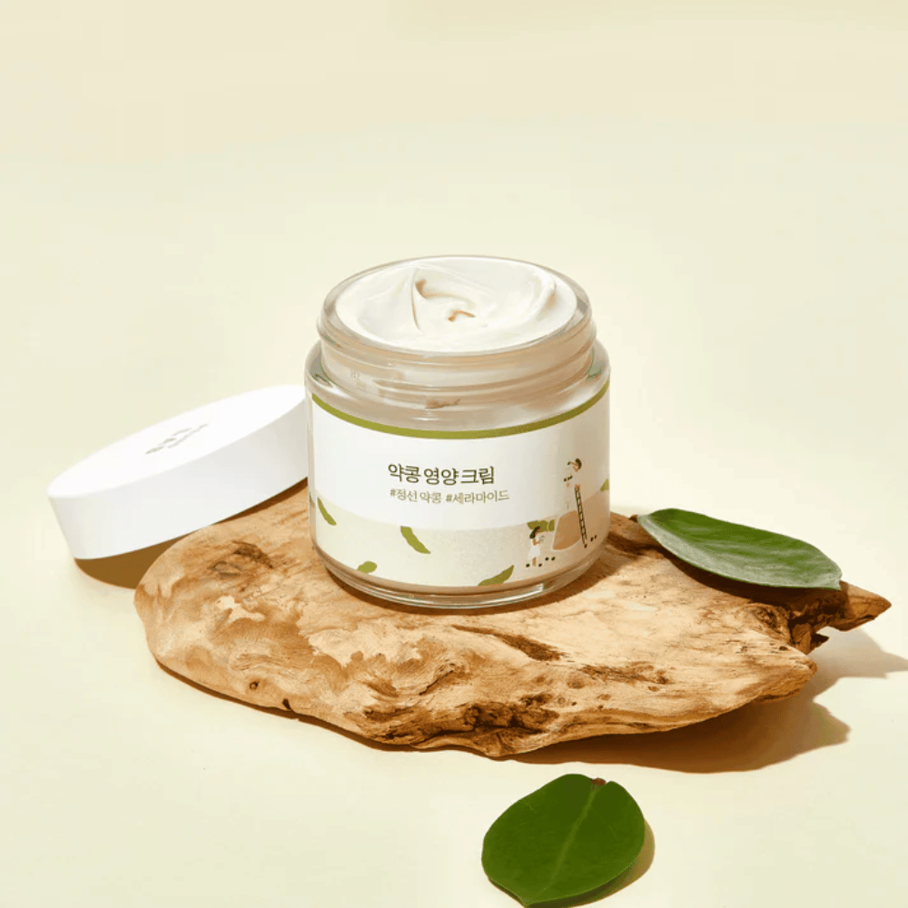 Mixsoon Soybean Nourishing Cream i åben bøtte på et træstykke med grønne blade. En næringsrig creme med fermenterede sojabønner og ceramider.