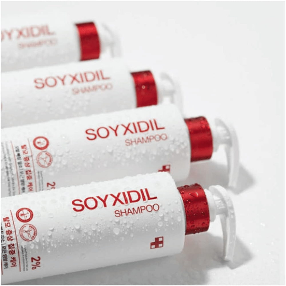 Flere flasker af Medicube Soyxidil Shampoo ligger på række med vanddråber – viser produktets friske og plejende følelse.