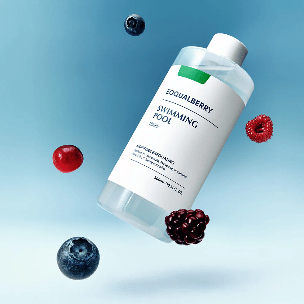 Equalberry Swimming Pool Toner i en stilren flaske svævende mod blå baggrund, omgivet af friske bær som blåbær, hindbær og brombær.