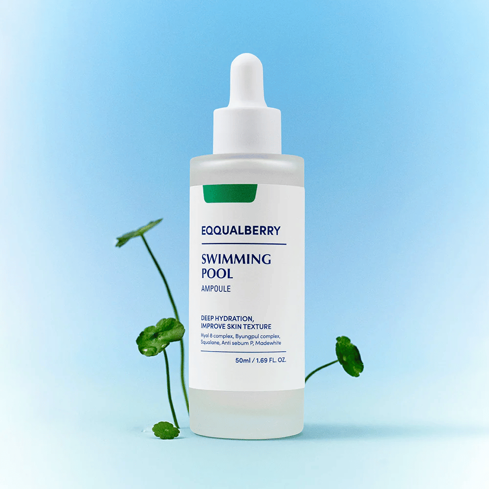 Flaske med Eqqualberry Swimming Pool Ampoule, et hudplejeprodukt til dyb fugtgivning og forbedret hudstruktur, placeret på en lyseblå baggrund med nogle grønne planter i forgrunden.