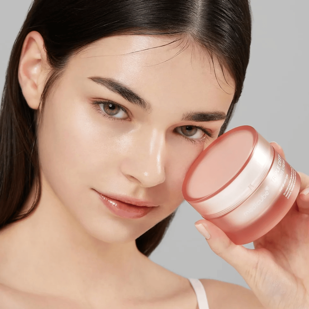 Billedet viser en kvinde, der holder en krukke med Triple Collagen Cream. Cremen er designet til at forbedre hudens elasticitet og fugtighed. Kvindens hud ser glat og velplejet ud.




