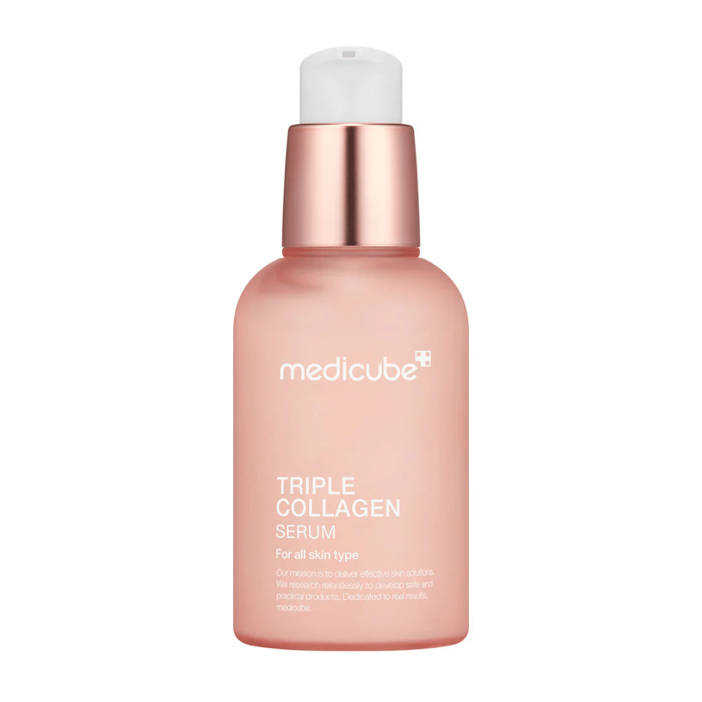 En lyserød flaske af Medicube Triple Collagen Serum, designet til alle hudtyper. Den glatte, frostede glasflaske med en metallisk lyserød hætte og hvid pumpe giver et elegant look, og teksten fremhæver serumets triple kollagenformel.