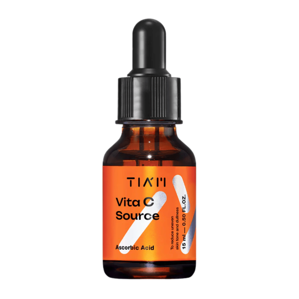 TIA'M Vita C Source, et serum med askorbinsyre i brun glasflaske med sort pipette og orange etiket – effektiv til at lysne huden og mindske ujævn hudtone.