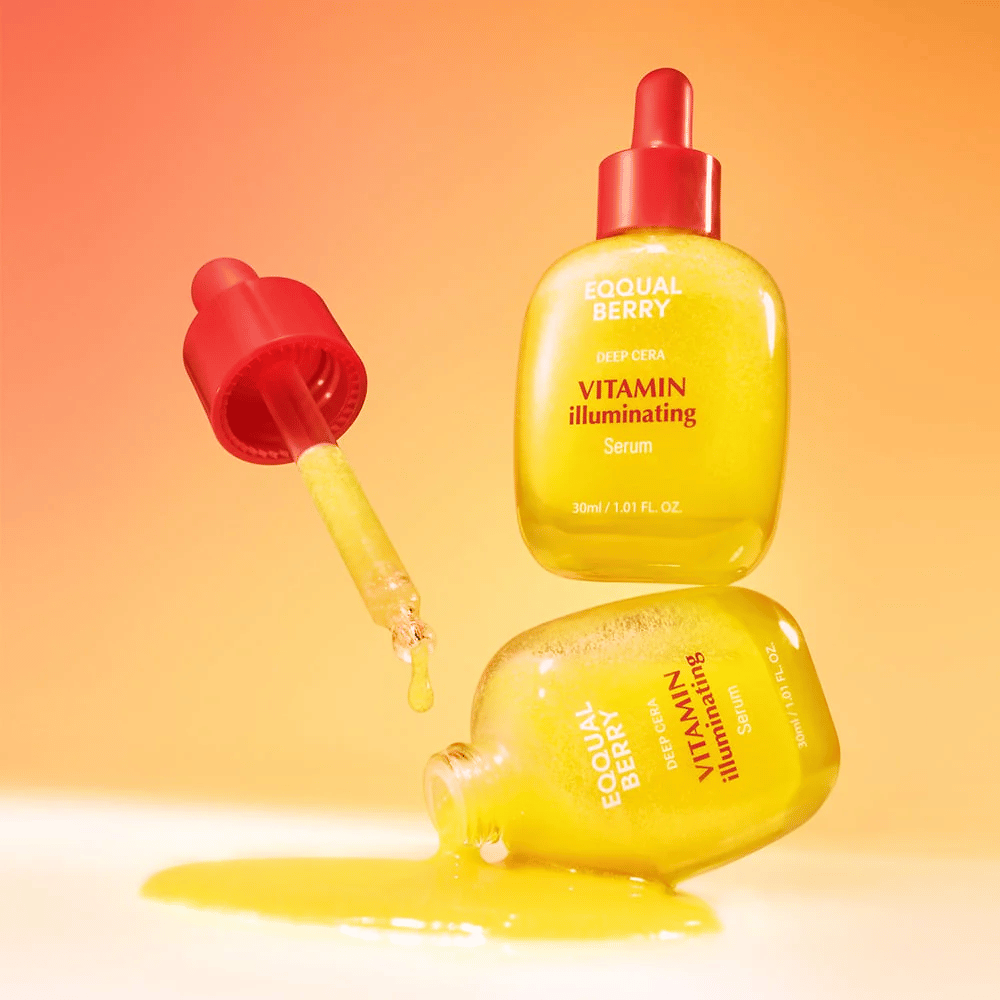 Equal Berry Vitamin Illuminating Serum i en lysende gul flaske med rød pipette. Flydende tekstur og energisk baggrund skaber en livlig og frisk følelse.