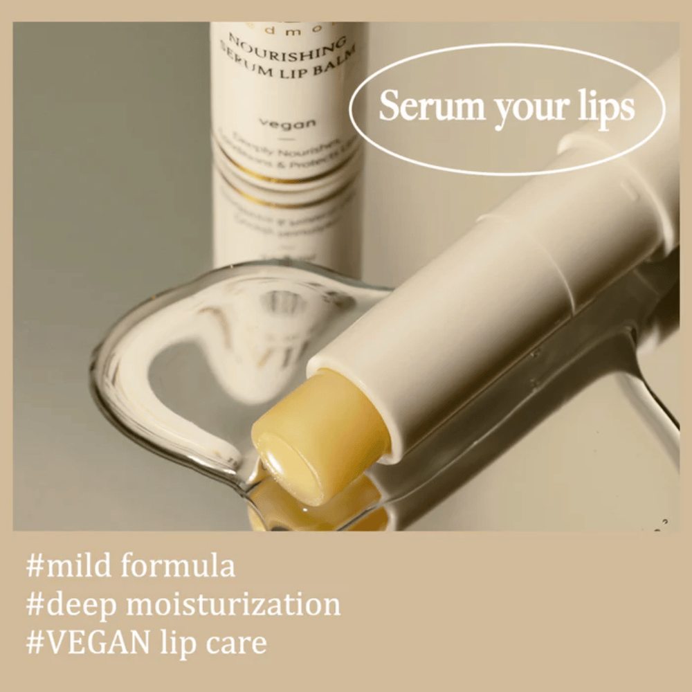 d'Alba Nourishing Serum Lip Balm i nærbillede liggende på spejl med tekst om mild formel, dyb fugtighed og vegansk læbepleje.