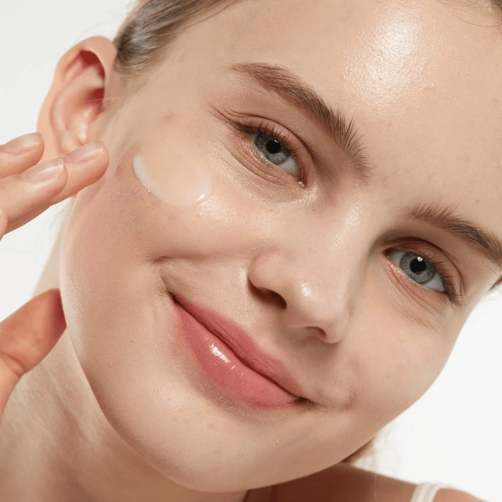 Model, der anvender Medicube Zero Pore Serum 2.0 på kinden, et porforfinende serum, der giver en jævnere hudstruktur, fugt og en naturlig glød.