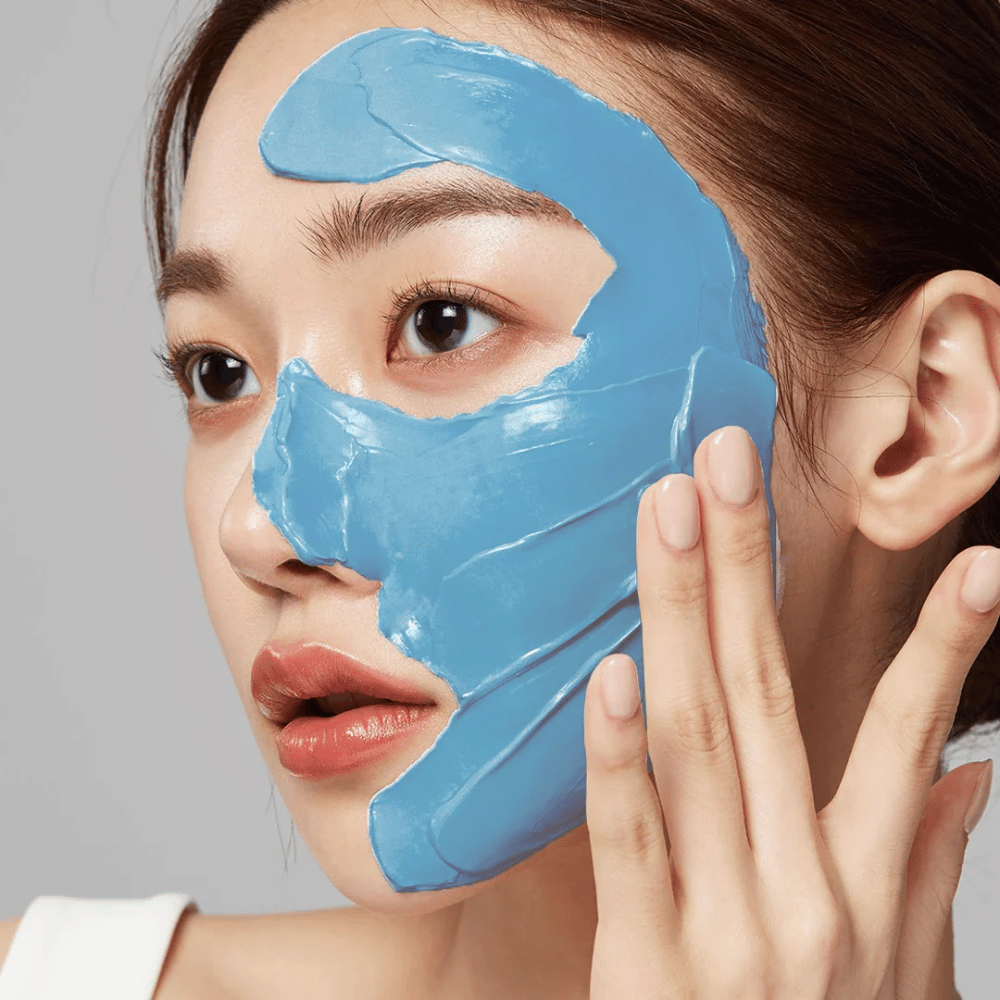 Model med blå ansigtsmaske fra Medicube, dækker T-zonen for porpleje.