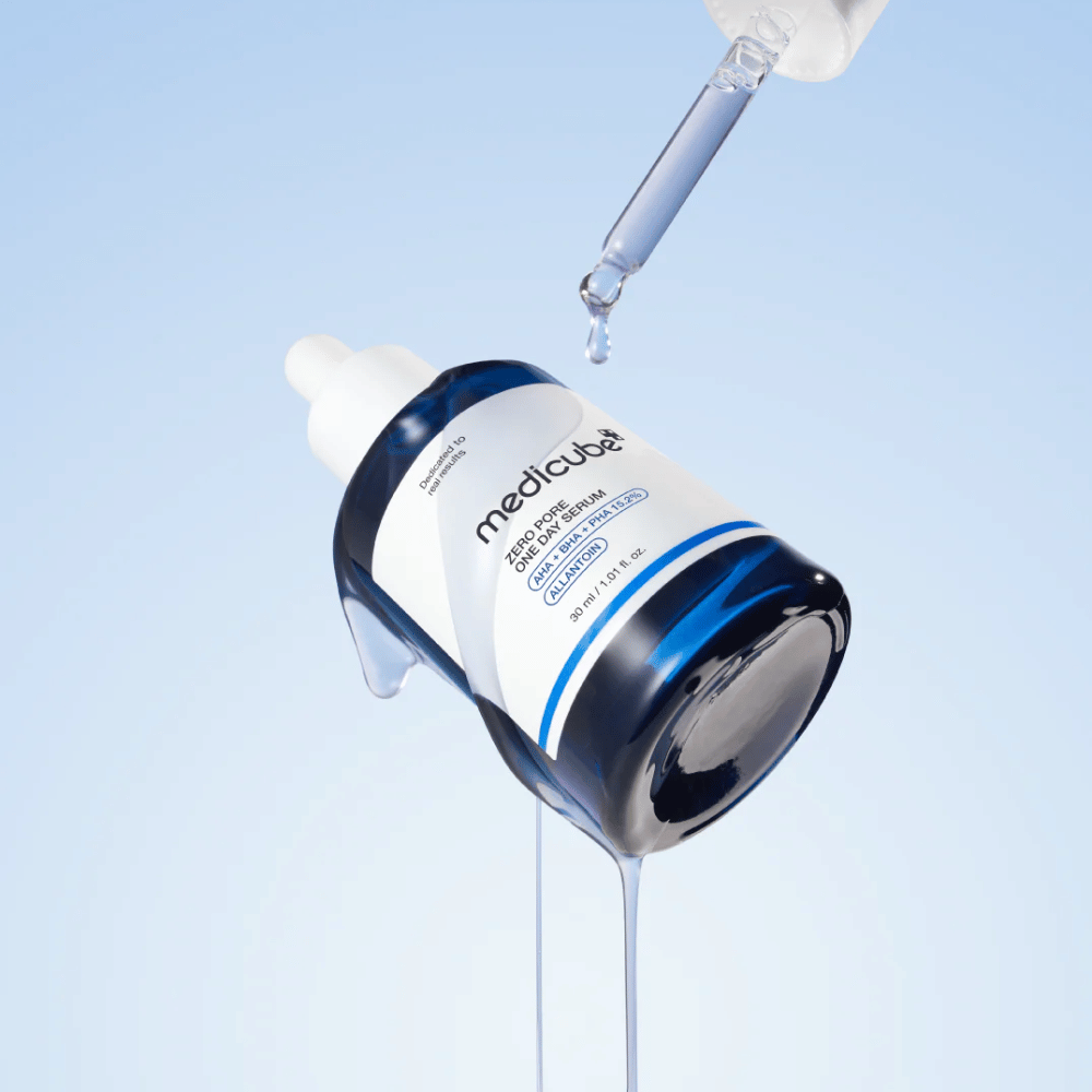 Flaske af Medicube Zero Pore One Day Serum med pipette og løbende serumdråber mod en lyseblå baggrund.