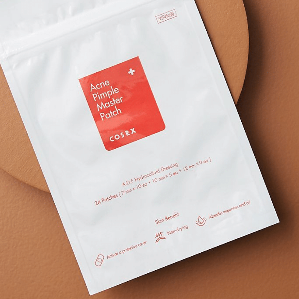En pakke COSRX Acne Pimple Master Patch (1pakke x 24 plaster) på en brun baggrund, med hydrocolloid teknologi til at behandle akne og bumser.
