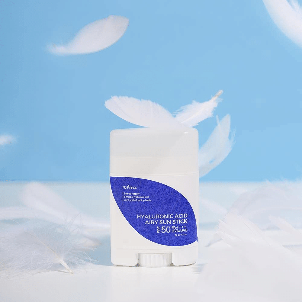 En Isntree Hyaluronic Acid Airy Sun Stick med SPF 50+ og Hyaluronic Acid, prydet med hvide fjer.