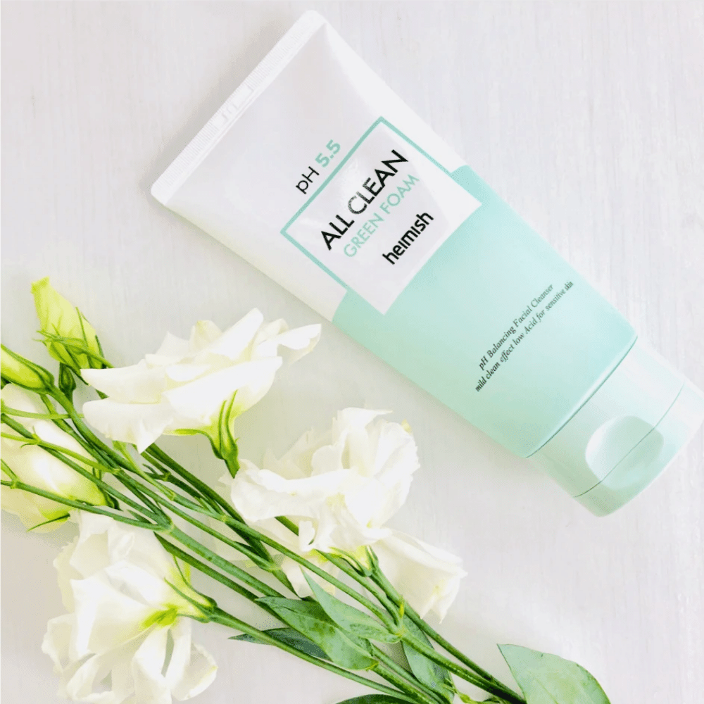 En tube heimish All Clean Green Foam 150ml ved siden af hvide blomster.