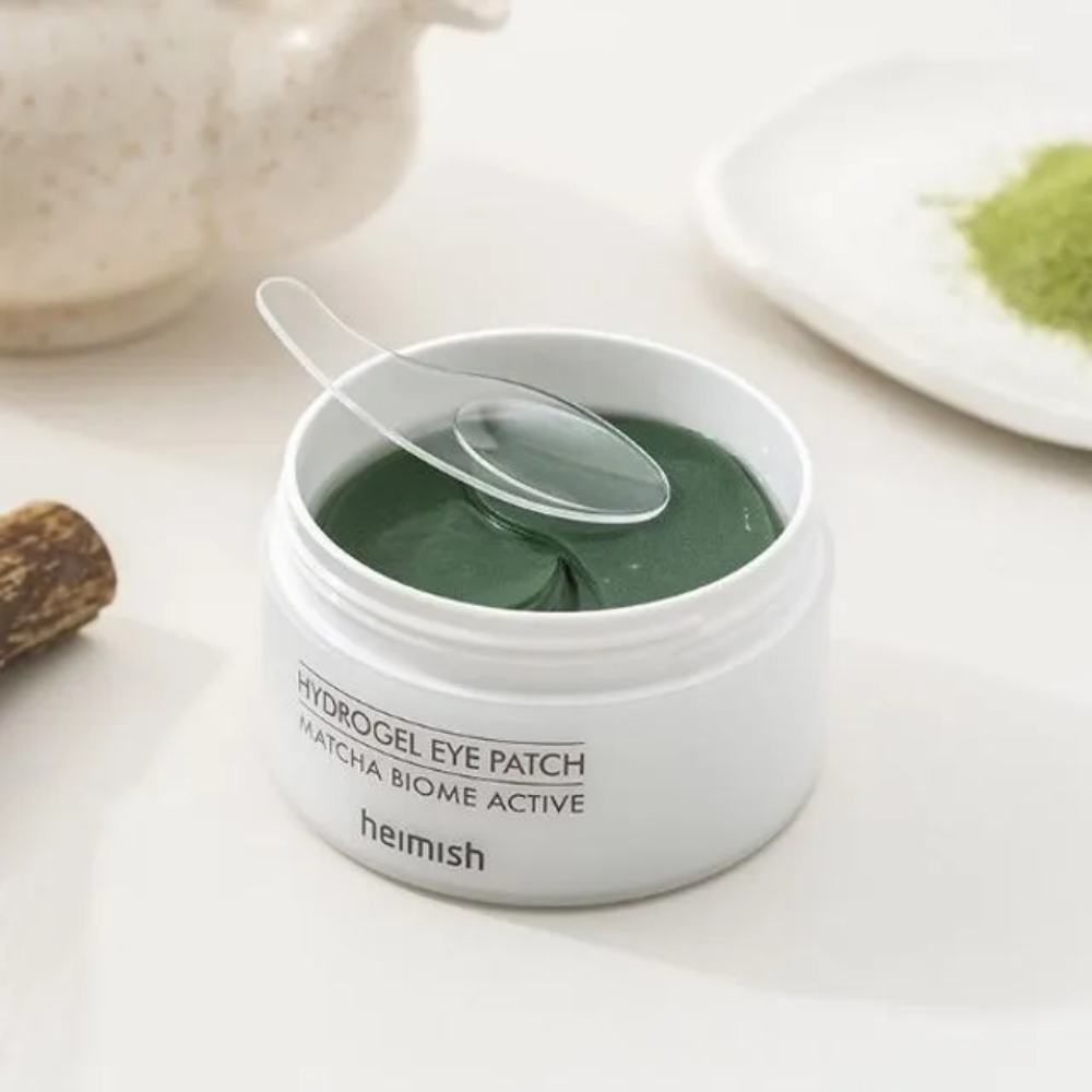 En skål med Heimish Matcha Biome Hydrogel Eye Patch 60 plastre med en ske.